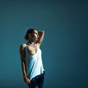 Justine sensueel poseren witte top blauwe achtergrond